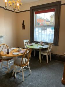 uma sala de jantar com duas mesas e cadeiras e uma janela em Number 29 - Only Adults em Shanklin