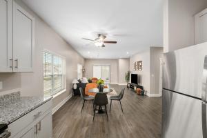 a kitchen and living room with a table and a refrigerator at Modern 2BR 2BA New Build Condo with Garage & Patio in Wyoming