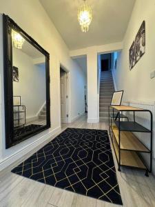a hallway with a mirror and a table and a staircase at Modern 5 Bed near ExCel -Big Ben in London