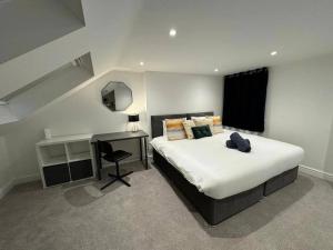 a bedroom with a large bed with a desk and a bed sidx sidx sidx sidx at Modern 5 Bed near ExCel -Big Ben in London