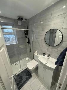 a bathroom with a sink and a toilet and a mirror at Modern 5 Bed near ExCel -Big Ben in London