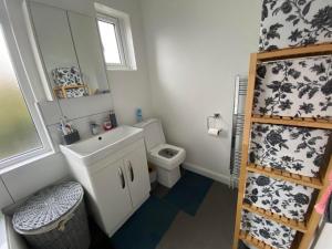 La salle de bains est pourvue d'un lavabo, de toilettes et d'un miroir. dans l'établissement Double Bedroom in Sudbury Hill Wembley - 10 mins from Wembley Stadium, à Harrow on the Hill