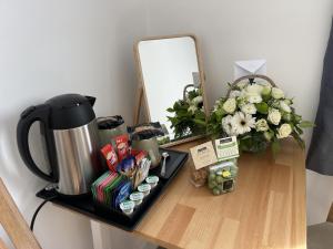 una mesa con una cafetera y flores en ella en Double Bedroom in Sudbury Hill Wembley - 10 mins from Wembley Stadium, en Harrow on the Hill