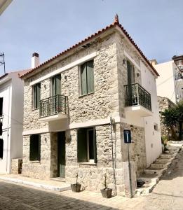 a stone house with two balconies on a street at Stone Villa in Pythagoreio