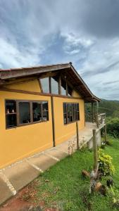 Chalé Sabiá في أيوريوكا: منزل اصفر صغير امامه سياج