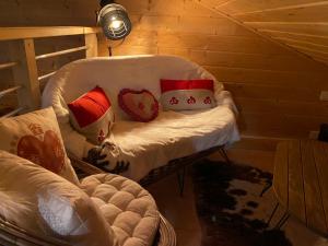 un sofá blanco con almohadas en una habitación en Chalet des Moineaux, en Saint-Laurent-du-Jura