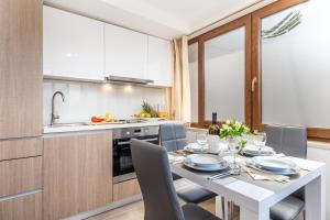 a kitchen and dining room with a white table and chairs at Apartment Srok, Relax in Kastav