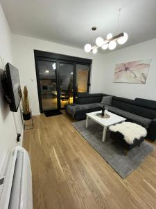 ein Wohnzimmer mit einem schwarzen Sofa und einem Tisch in der Unterkunft Premium Center in Trebinje
