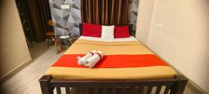 1 dormitorio con 1 cama con una manta colorida en Cochin Hotel Inn, en Ernakulam