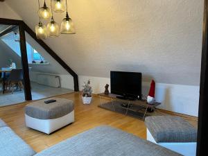 a living room with a flat screen tv and a couch at Pension Hotel Leinefelde am Bahnhof in Leinefelde