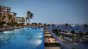 a large swimming pool with chairs and palm trees at Dubai careek Harbour in Dubai