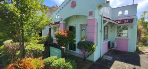 een huis met roze en witte verf bij Molave Model House in Pook