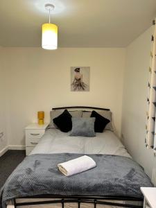 a bedroom with a bed with a blanket and a lamp at Lovely Town house Room 4 in Parkside