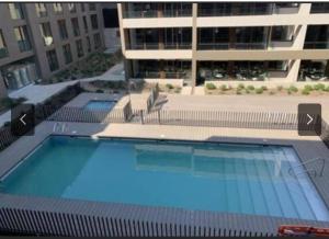 a large swimming pool in front of a building at Hermoso Lofts Centro De Santiago in Santiago