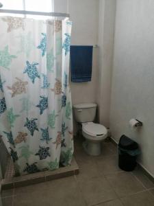 ein Bad mit einem WC und einem Duschvorhang in der Unterkunft Casa Privada Palmas 10 con Alberca in Kanasín