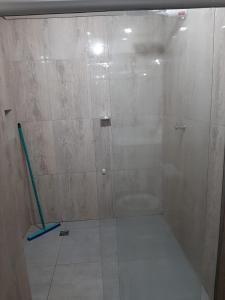 a shower with a glass door in a bathroom at Apartamento confortável in Goiânia
