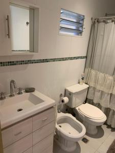 a bathroom with a white toilet and a sink at Departamento Parana 1 in Posadas +12 photos