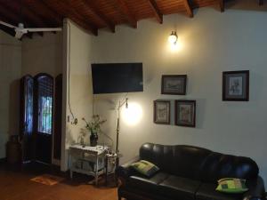 a living room with a leather couch and a flat screen tv at Quinta La calmita Iguazú in Puerto Iguazú
