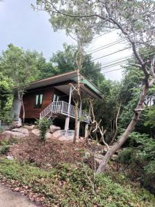 a house with a porch in the woods at Salamao Bungalow in Ko Tao