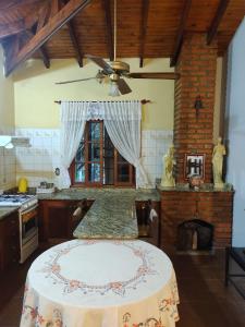 a kitchen with a table and a ceiling fan at Quinta La calmita Iguazú in Puerto Iguazú