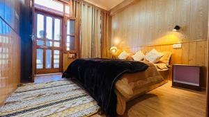 una camera da letto con un letto, un divano e una finestra di The Ivy Mansion Sethan a Manāli