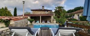 a patio with chairs and a swimming pool at La Marguerite in Brossac