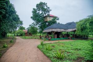 a house with a tower on top of a dirt road at Animal View Point Yala in Tissamaharama