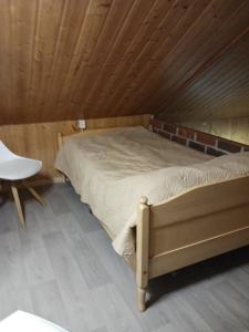 Cama en habitación con techo de madera en Perälampi, en Huissi