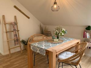 ein Esszimmer mit einem Tisch und Stühlen mit Blumen darauf in der Unterkunft Landhaus Bachglück in Zülpich