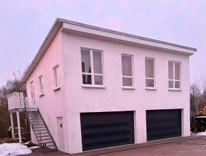 una casa rosa con dos puertas de garaje en Cottage an der Elbe Tespe Hamburg en Tespe