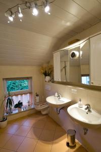 a bathroom with two sinks and a toilet and a mirror at My CozyPlace - Zwei Zimmer für 4 Personen in Dresden
