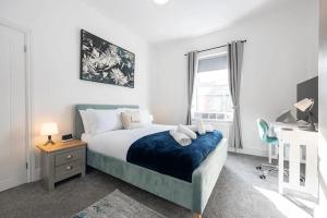 Een bed of bedden in een kamer bij Stunning 4BD House with Patio in Fallowfield