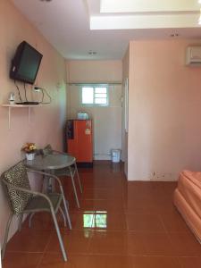 ein Wohnzimmer mit einem Tisch und einem roten Kühlschrank in der Unterkunft Baan I Mhok Suanphueng in Suan Phung