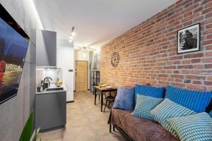 a living room with a couch and a brick wall at Kotlarska Snug Escape in Wrocław