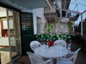 d'une table et de chaises blanches sur un balcon. dans l'établissement Sea Garden, fronte mare con piscina, à Mascali