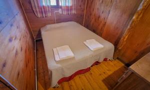 a small room with a bed in a wooden cabin at El Camino in Villa Berna