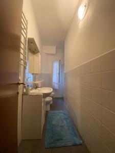 a bathroom with a sink and a toilet and a mirror at Right Bank House in Imperia