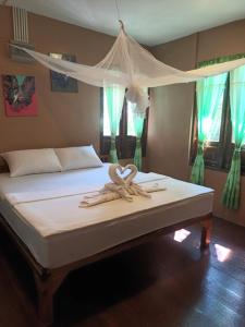 - une chambre avec un lit à baldaquin et des draps blancs dans l'établissement Salamao Bungalow, à Koh Tao