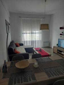 ein Wohnzimmer mit einem Sofa und einem Tisch in der Unterkunft Apartman Tea in Kupres
