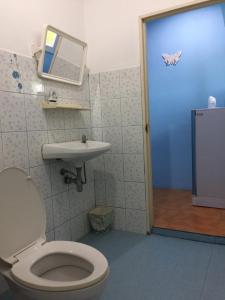 un bagno con un water, un lavandino e uno specchio di Baan I Mhok Suanphueng a Suan Phung