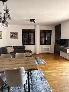 a living room with a table and a couch at Apartman Jedro Lux in Rafailovici
