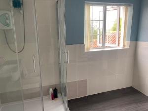 a bathroom with a shower with a glass door at Wellbet Farm in Lincoln