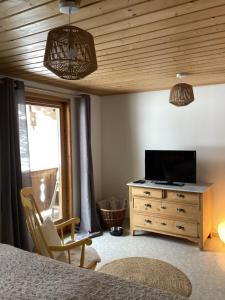 een slaapkamer met een bed en een dressoir met een televisie bij Apartement für Naturliebhaber in Fischbachau