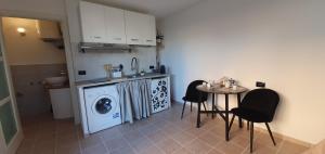 une cuisine avec un lave-linge et une table avec des chaises dans l'établissement Eleonora's apartment, à Olbia