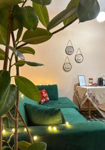 uma sala de estar com um sofá verde e uma mesa em Villa Malo Guesthouse em Korçë
