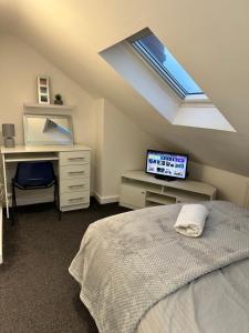 Schlafzimmer mit einem Bett, einem Schreibtisch und einem Dachfenster in der Unterkunft Lovely Town house Room 5 in Parkside