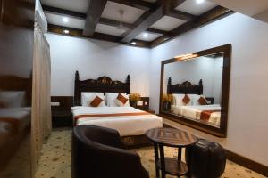 迈索尔Hotel Lok Sagar Mysore的有两张床和一面镜子的酒店房间
