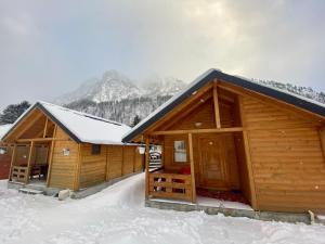 a couple of wooden cabins in the snow at 2E Villa’s Valbone in Valbonë