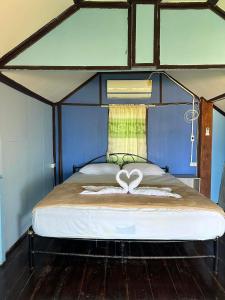 Schlafzimmer mit einem Bett mit Herzdekoration in der Unterkunft Libong Garden Beach in Ko Libong