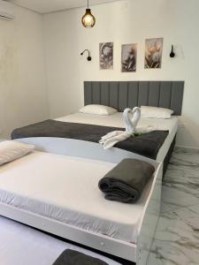 duas camas num quarto com toalhas e cisnes em pousada fast sleep no Guarujá